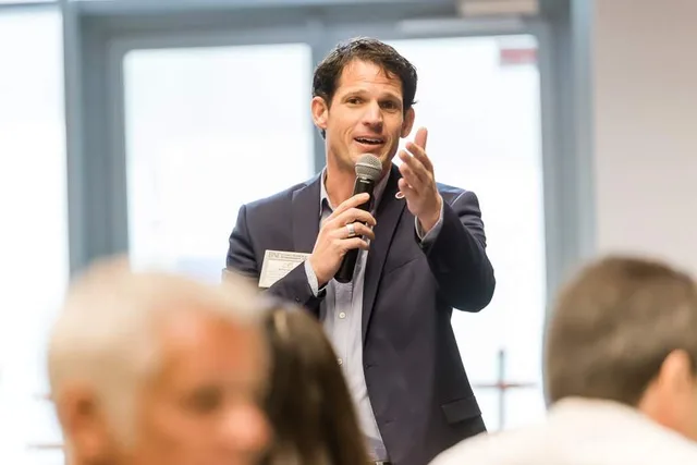 Matthieu Daumain, micro en main, devant une salle d'entrepreneurs